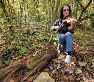 andi leahy black haired woman playing fiddle violin in forest